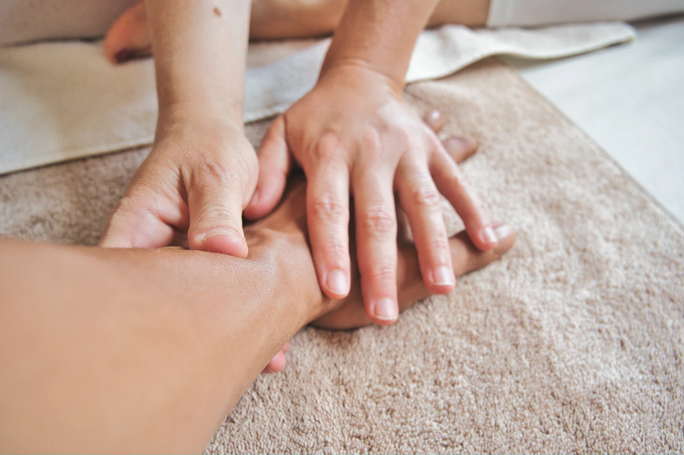 Twee handen die een onderarm masseren